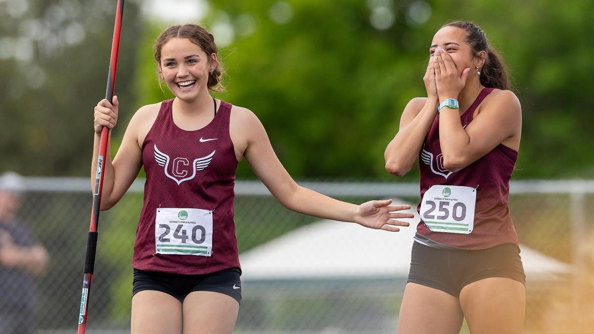 Centennial freshman Jaylen Matsushita, left, congratulates senior teammate Eliana Ti’a, right. Ti’a threw a winning 129-10 in the javelin throw on the final day of the 6A District Three track and field championships Friday at Meridian High School. Matsushita took third place with a throw of 113-02.