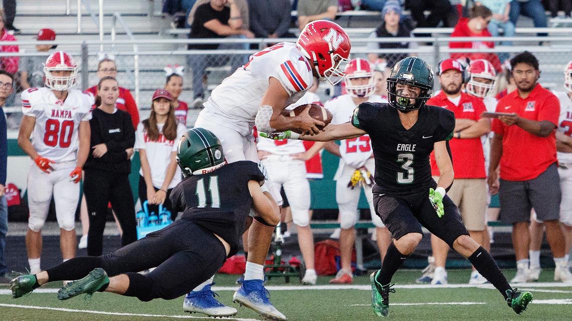 Eagle defensive backs Gavin Crawford, left, and Kenton Marzocco, right, bring down Nampa tight end Payton Gunter on Friday at Eagle.