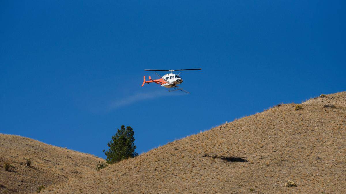 This Oct. 4, 2021, U.S. Forest Service photo shows contract helicopter pilot Andy Orr spraying herbicide in the Fourth of July Creek area as part of an ongoing weed management project. The herbicide also ended up on private property, prompting distrust in the agency and health concerns from veterans who’ve previously been exposed to harmful pollutants.