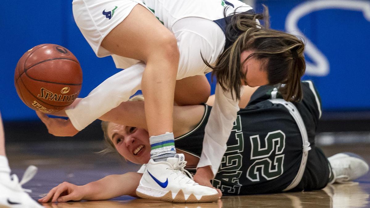 Eagle senior Dana Murray stretches to get the basketball with Mountain View’s Laila Saenz on a loose ball scramble during the 5A District Three girl’s basketball championship Friday, Feb. 8, 2019 at Timberline High School in Boise. Mountain View won the game 46-34 remaining undefeated at 23-0 heading into the state tournament next week.