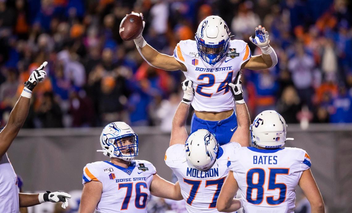 Boise State running back George Holani is hoisted into the air by offensive lineman John Molchon after his touchdown in the third quarter of the Broncos’ 38-7 loss to Washington in the Las Vegas Bowl.