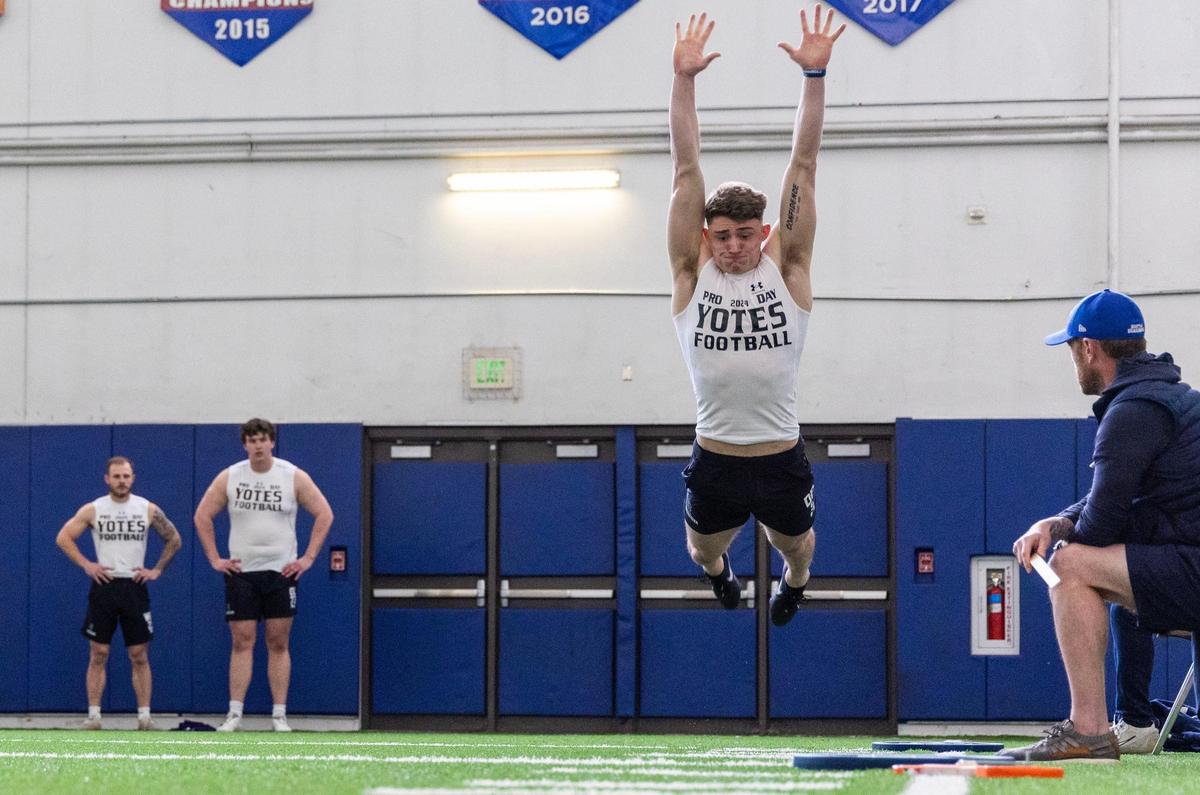 Former College of Idaho defensive back Chip Mitchell stretches out in broad jump for professional football scouts, Tuesday, March 26, 2024, at Pro Day at Boise State in Boise. Scouts recorded, measured and evaluated collegiate athletes from Boise State, the College of Idaho and Idaho State University.