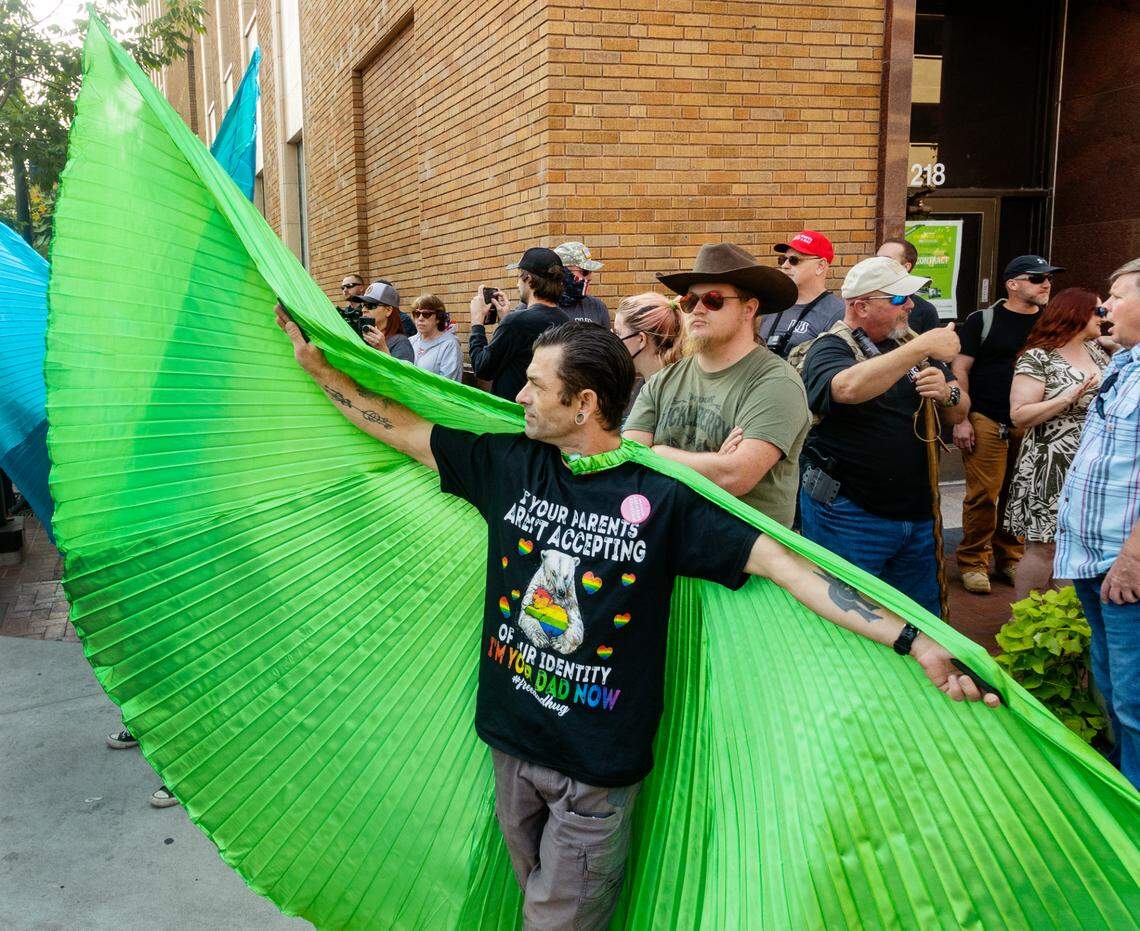A man who goes by Je uses large green wings to put a wall between a small group of protesters standing outside the entrance of the Boise Pride Festival on Sunday, Sept. 11, 2022. The annual event faced backlash from some community members asking sponsors of the three-day event to pull their funding because a children’s drag show performance was on the schedule.