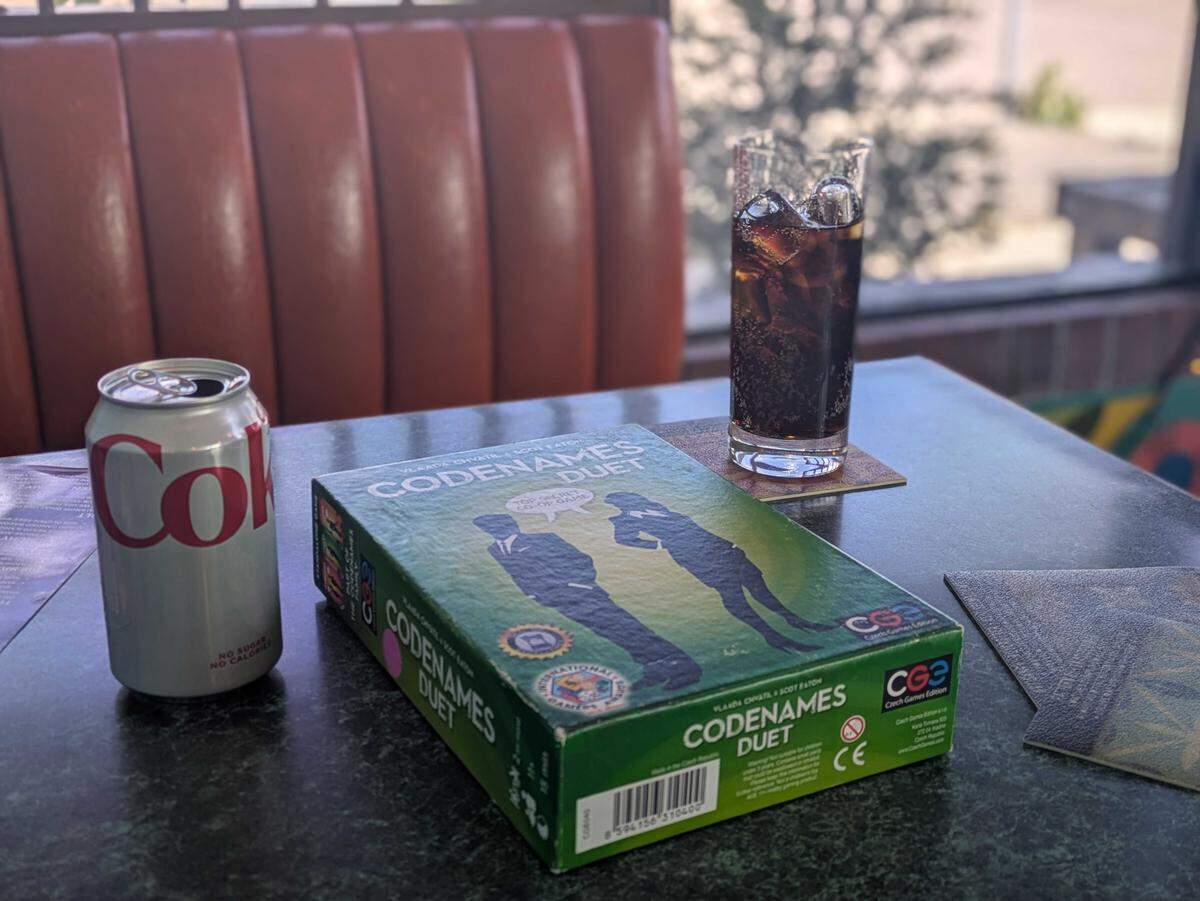 A crisp Diet Coke placed beside a box of Codenames: Duet. Idaho Statesman reporters Carolyn Komatsoulis and Hali Smith stopped by the Chits and Chats board game pub for “On a Budget.”