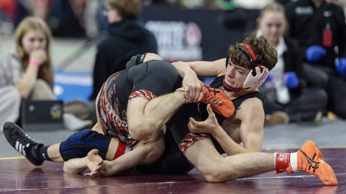 Nampa's Ryan Hirchert, top, competes with Shelley's John Behm in the 5A 113-lbs. division first place match at the Idaho state wrestling championships held at the Ford Idaho Center in Nampa, Saturday, Feb. 28, 2026. Hirchert won.