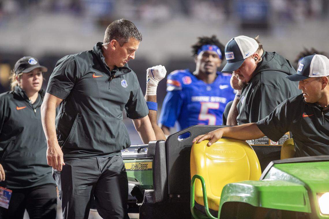 Boise State cornerback Jaden Mickey holds a hand in the air while being carted off the field after an injury during Saturday’s game.