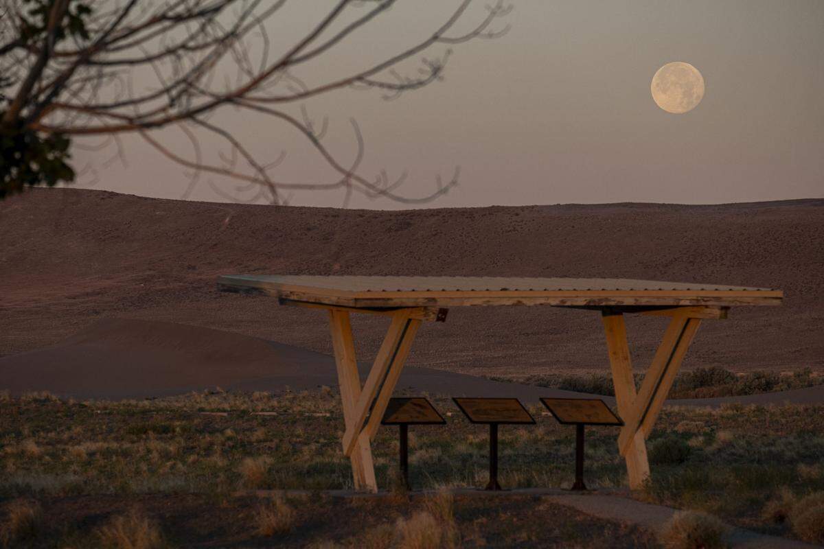 The strawberry full moon sets over the dunes of Bruneau Dunes State Park, Thursday, June 24, 2021, south of Bruneau.