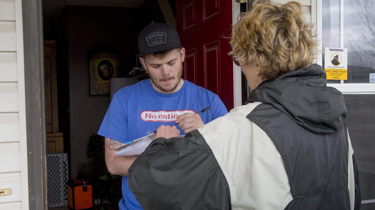 Trevor Buffi, of Nampa, in April 2018 signs a petition to hold a Medicaid expansion vote in Idaho after meeting volunteer Laurie Durocher at the door.  Medicaid expansion later passed with the support of 60 percent of voters.