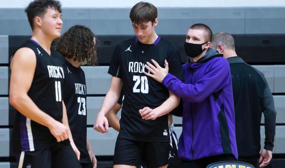 Taking on a new role as an assistant coach, senior Jaden Hansen supports sophomore Drew Fielder on Friday at Capital High.