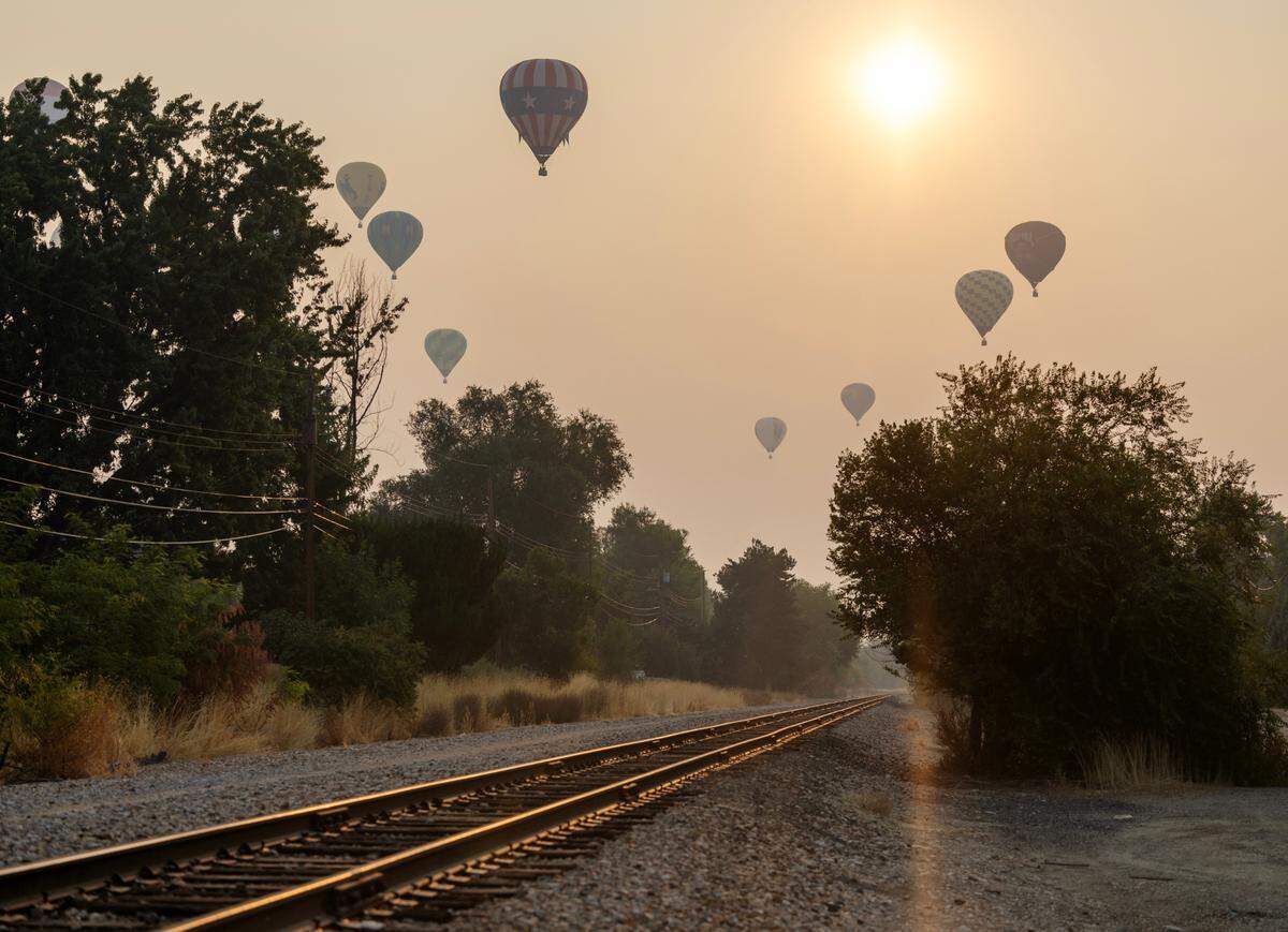 Hot air balloons fly in smoky skies over Boise during Friday’s Spirit of Boise event.