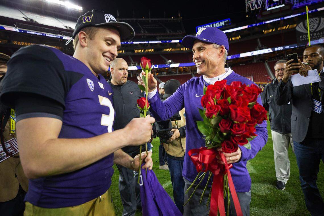 Chris Petersen presents Jake Browning two roses after the Huskies defeated Utah to get into the Rose Bowl Friday, Nov. 30, 2018 in Santa Clara, Calif. Washington beat Utah 10-3. (Dean Rutz/Seattle Times/TNS)