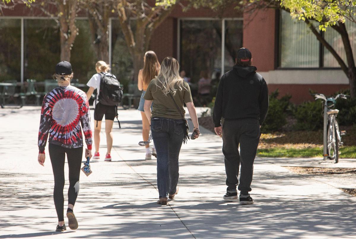 Boise State University is part of an alliance of six colleges and universities piloting student-designed programming to address certain issues. Students walk between buildings on campus in April.