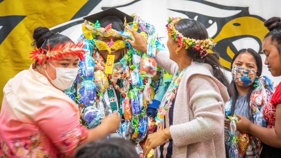 In a traditional Micronesian showering of gifts, Ancherson James is happy with his non-traditional Capital High School graduation ceremony on Monday. “I feel grateful and love,” he said.