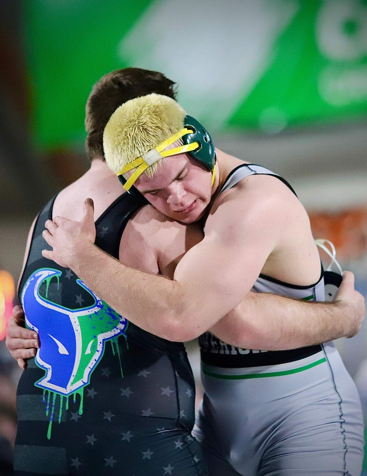 Mountain View teammates and longtime wrestling partners Shiloh Jones (facing) and Aiden McGinnis share a hug Saturday after their heavyweight championship about at the ICCU Dome in Pocatello.