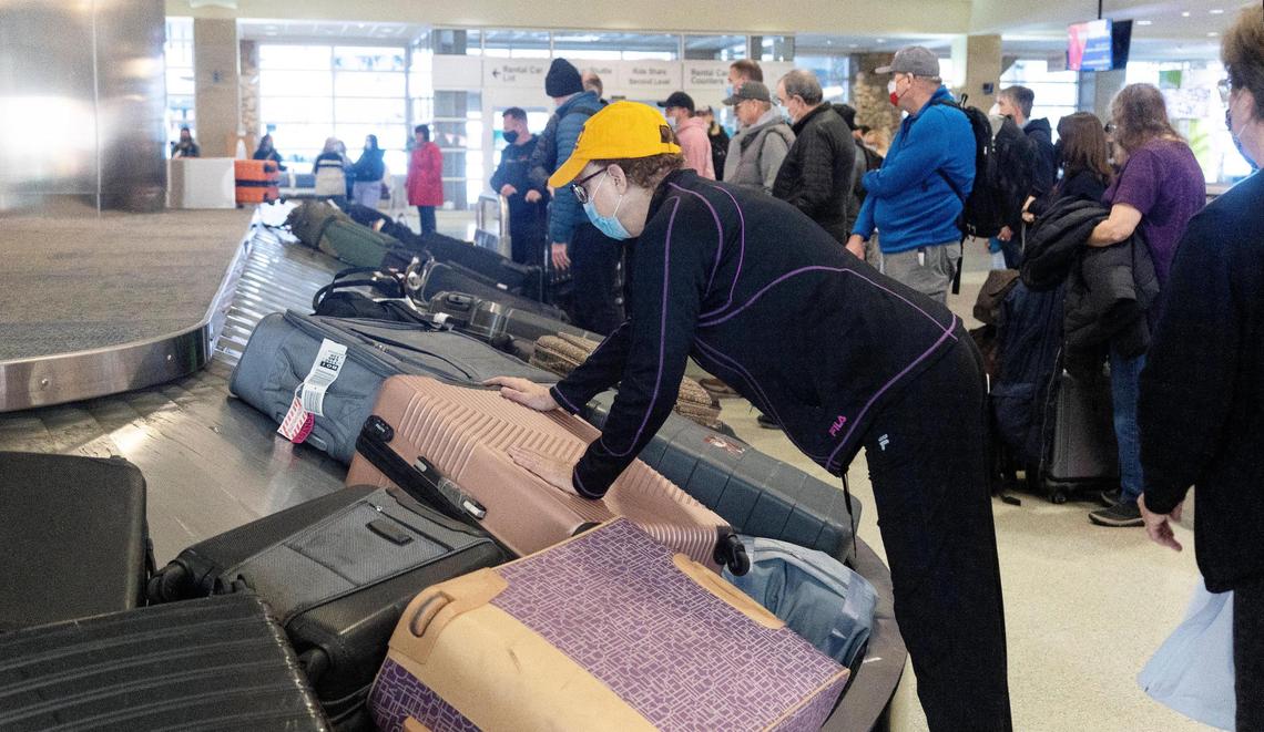 Travelers wait for their luggage at the carousels in the Boise Airport around the year-end holidays in December 2021.