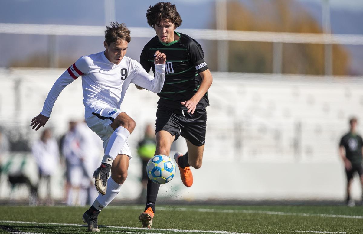 Mountain View’s Nick Bisango clears the ball away from Eagle’s Truman Hoggan in the first round of the 5A boys soccer state tournament Oct. 24 at Eagle High.