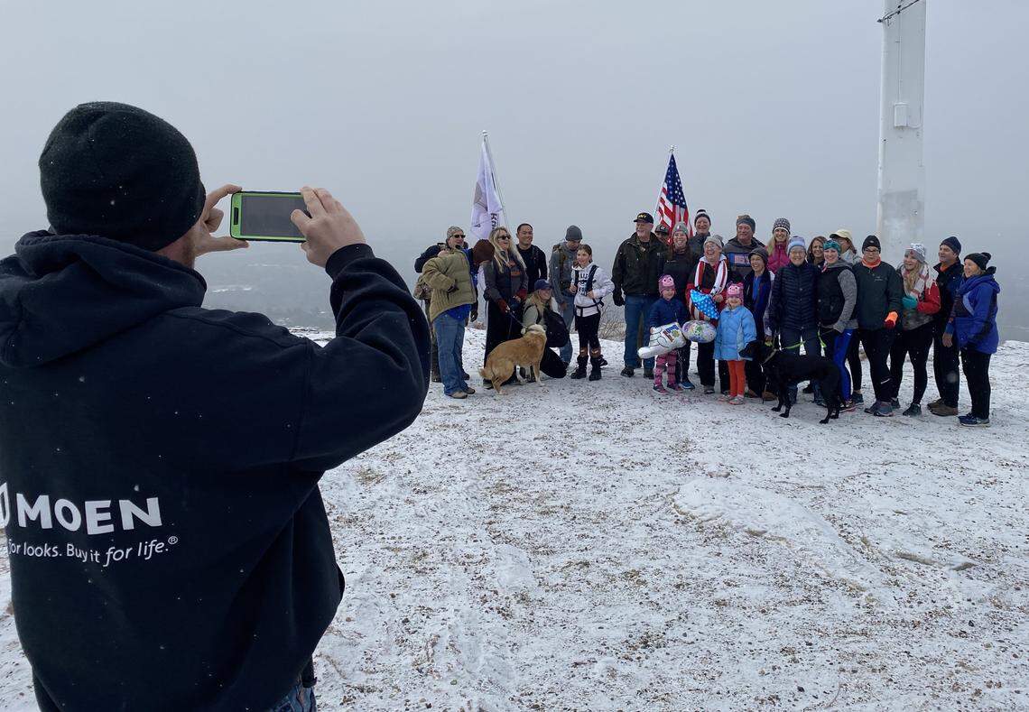 Mitzi Cheldelin, center in red and white scarf, poses with friends at the top of Table Rock Trail on Sunday, Dec. 29, 2019. Cheldelin hiked to the top of Table Rock 100 times in 2019, and nearly 25 friends joined her for the final trek.