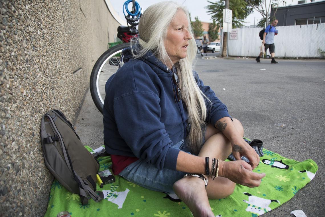 Tracy Foy waits for the line at Interfaith Sanctuary to clear out before she heads into the shelter for the night.