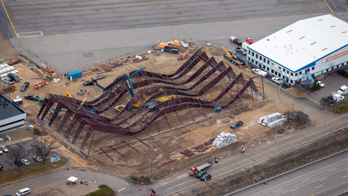 This aerial photo from early 2024 looking southwest shows the wreckage of the hangar in center with cars traveling on Interstate 84 at bottom. A Firehawk Helicopters building can be seen at right and Jackson Jet Center at left.