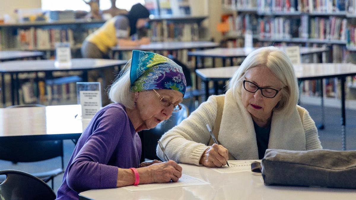 Kathy Dzuck and Melody Ploetz vote in the Idaho Democratic presidential caucus at Timberline High School in Boise on Thursday.
