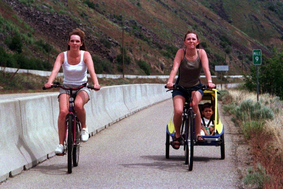 Tina Karlson and Suzanne Karlson ride along the Greenbelt with little Kyle Martinez enjoying the ride on Memorial Day 1999.