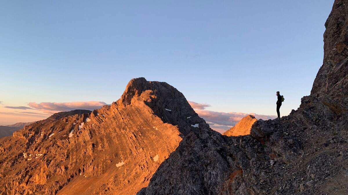 Daniel Todd looks on as early morning light comes over the Riddler, one of fifteen peaks in the Lemhi Range that Todd and climbing partner Haylee Stocking traversed in 26 hours.