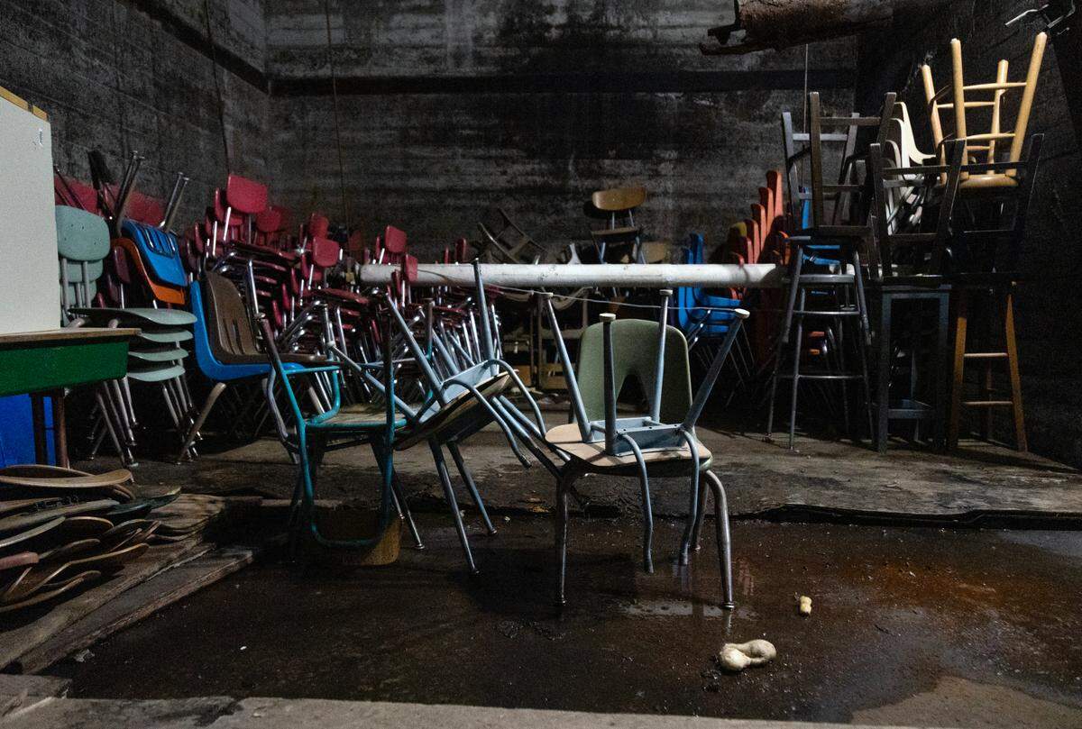 Water seeps across the floor in the boiler room.