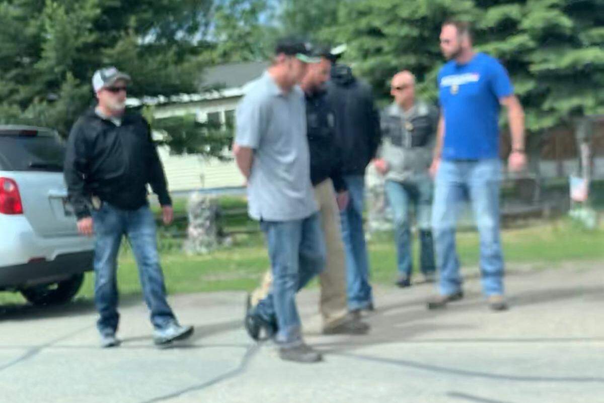 This fuzzy cellphone photo shows a man identified as Chad Daybell being taken into custody Tuesday.