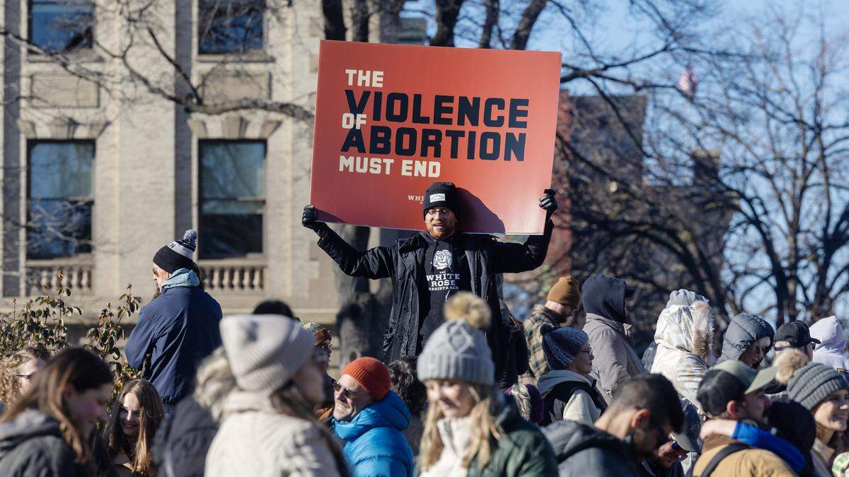 People hold anti-abortion signs at a rally at the Idaho Capitol on Saturday.