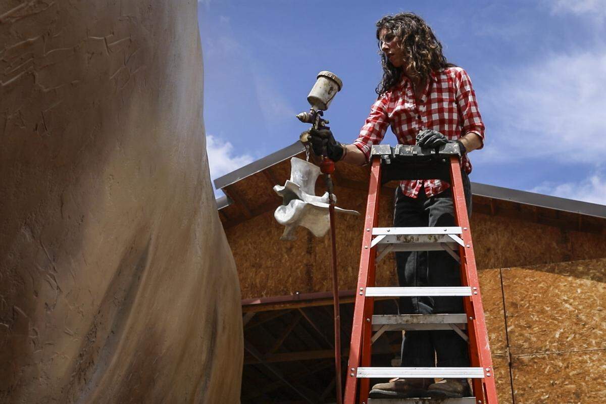 Sharolyn Schofield paints the Big Idaho Potato in Weiser on Monday. Schofield developed the right color for the potato by mixing brown with a number of other colors.