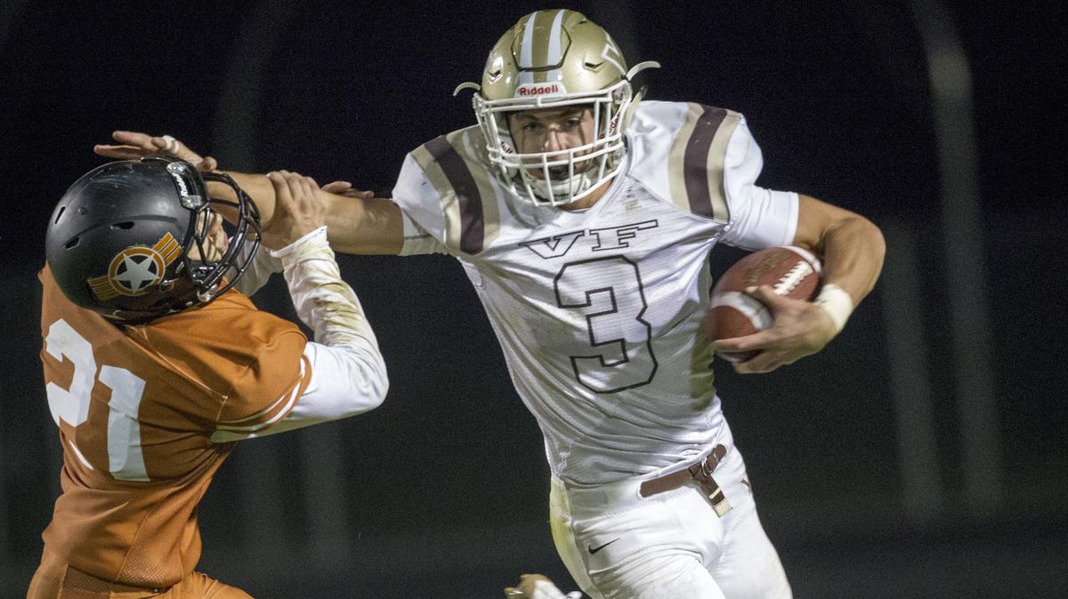 Vallivue quarterback Lan Larison stiff arms and sheds Ridgevue defender Quinn Rodriguez during the Falcons’ 49-20 win at Ridgevue High on Friday.