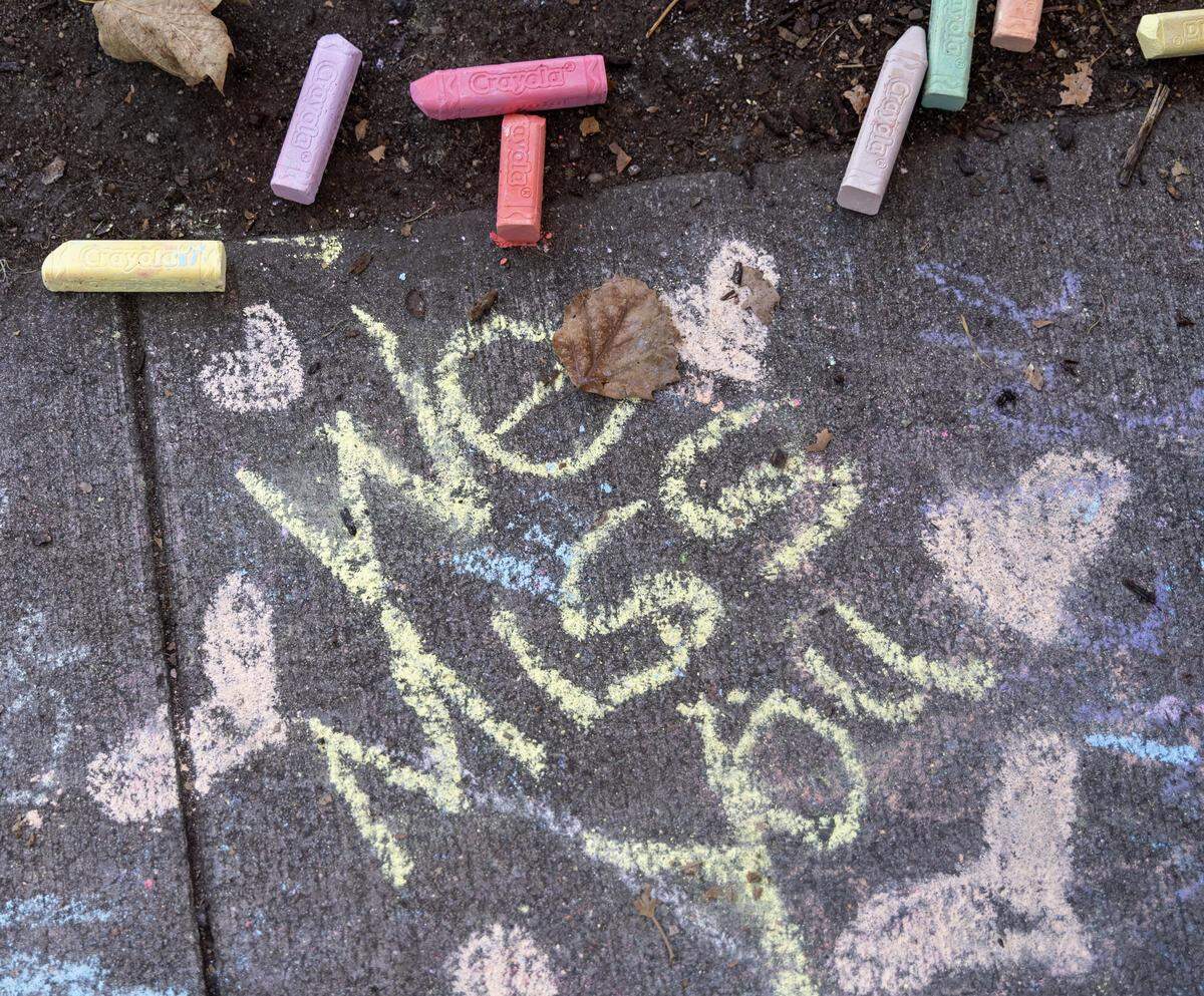 Chalk messages add to a memorial to Mora Gerety, a child who was killed by a vehicle while crossing the street, is set up at the intersection of Harrison Blvd. and Ada St. in Boise.