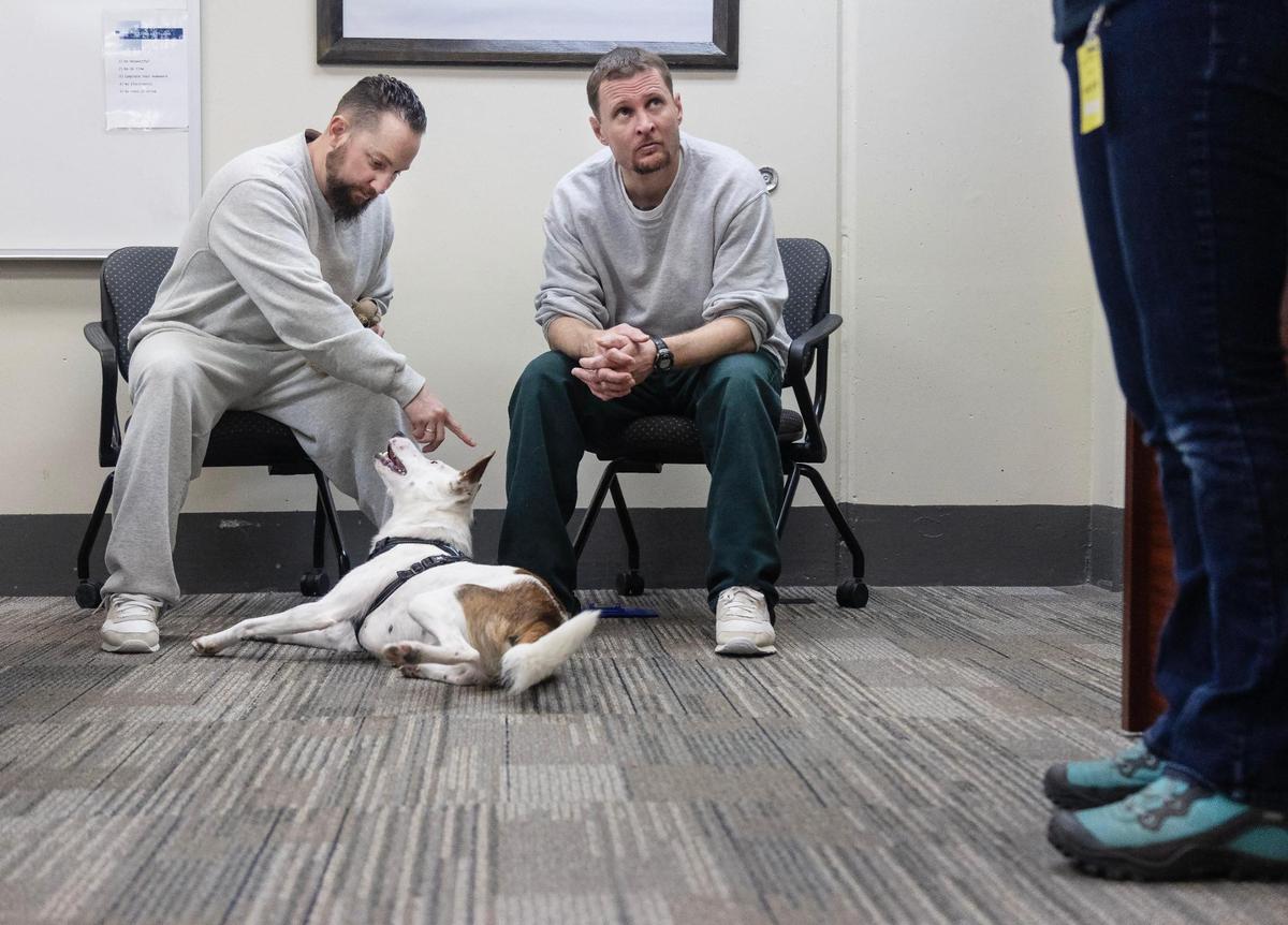 Idaho State Correctional Center inmates Aaron Dechand, left, and Adam Bodenbach, right, attend a dog training class at the jail with Jessica Ewing, executive director of Meridian Canine Rescue, on Jan. 3, 2022. Through a partnership between ISCC and Meridian Canine Rescue, the Education Project for Inmates & Canines (EPIC) pairs shelter dogs with inmates who work to train the animals using positive reinforcement and behavior modification techniques.