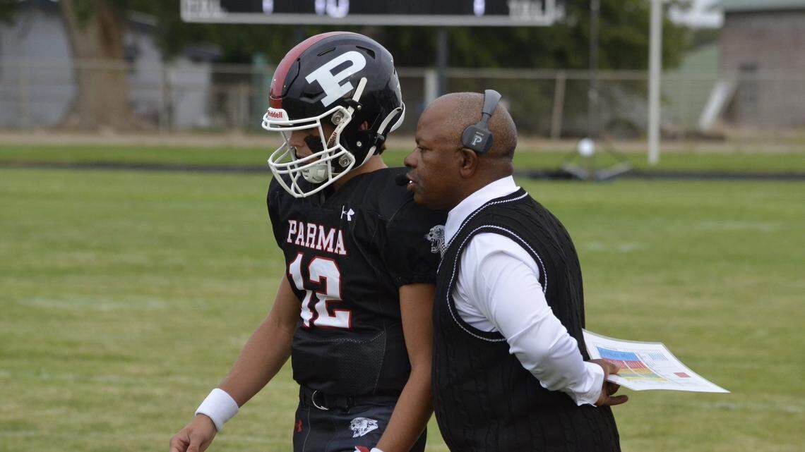 Parma coach Jarome Bell talks to sophomore QB Domingo Asumendi during a game this season. Bell is in his first year at the school. He does not teach at Parma, serving only as the head football coach.