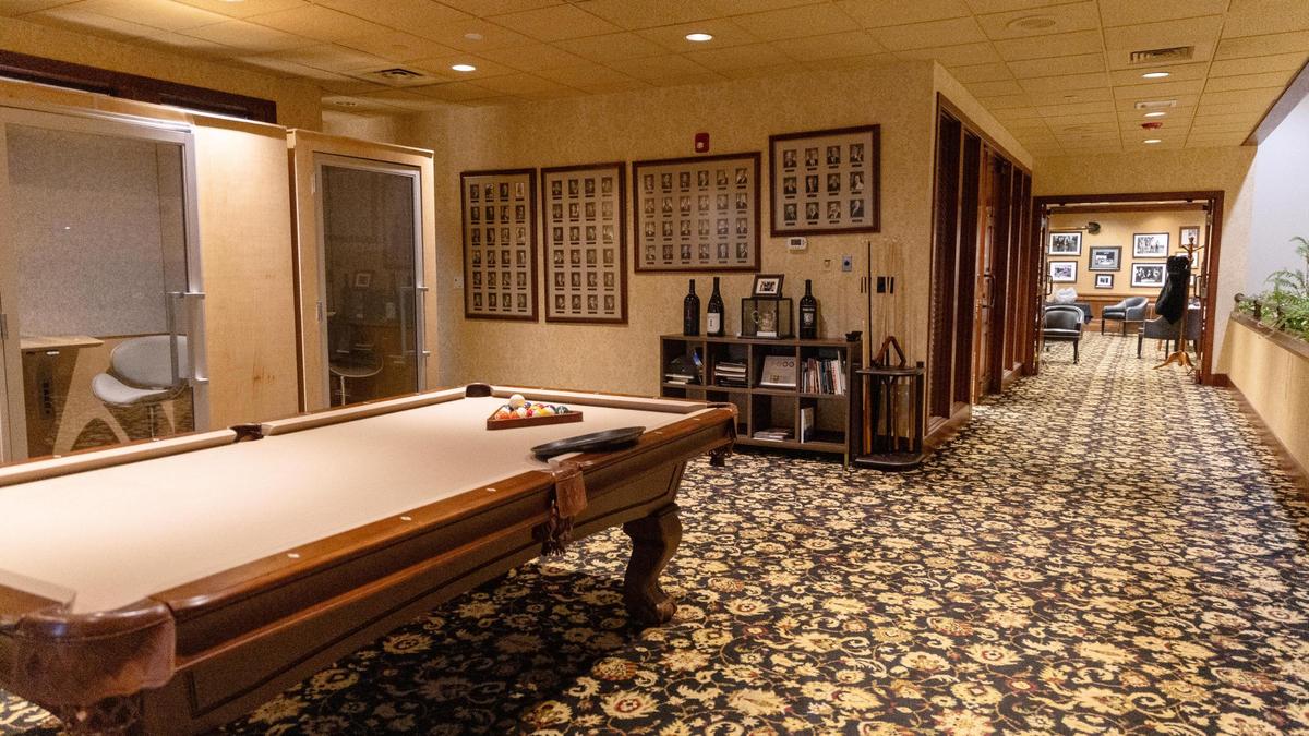 Pictures of past board members hang on the walls of the Arid Club’s second floor, where members gather to play billiards.