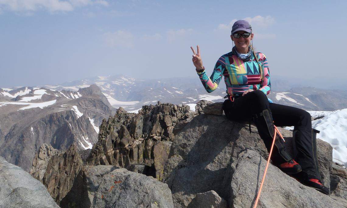 Terri Rowe, of Meridian, sits on top of Gannett Peak, the highest point in Wyoming, while holding up two fingers to symbolize her second time climbing each of the highpoints in the lower 48. Rowe became the first woman to climb all 48 highpoints twice.