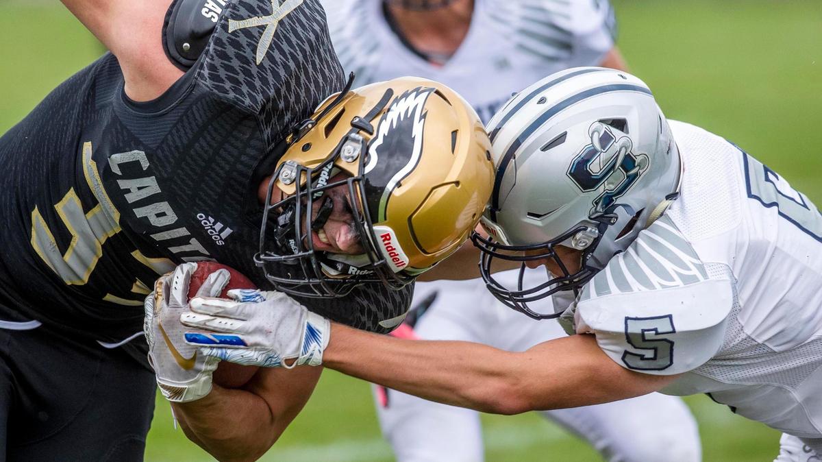 Capital wide receiver Jackson Reed fights through an attempted tackle by Skyview’s Gavin Coffman to plow in for one of his four touchdown catches Friday at Capital High.