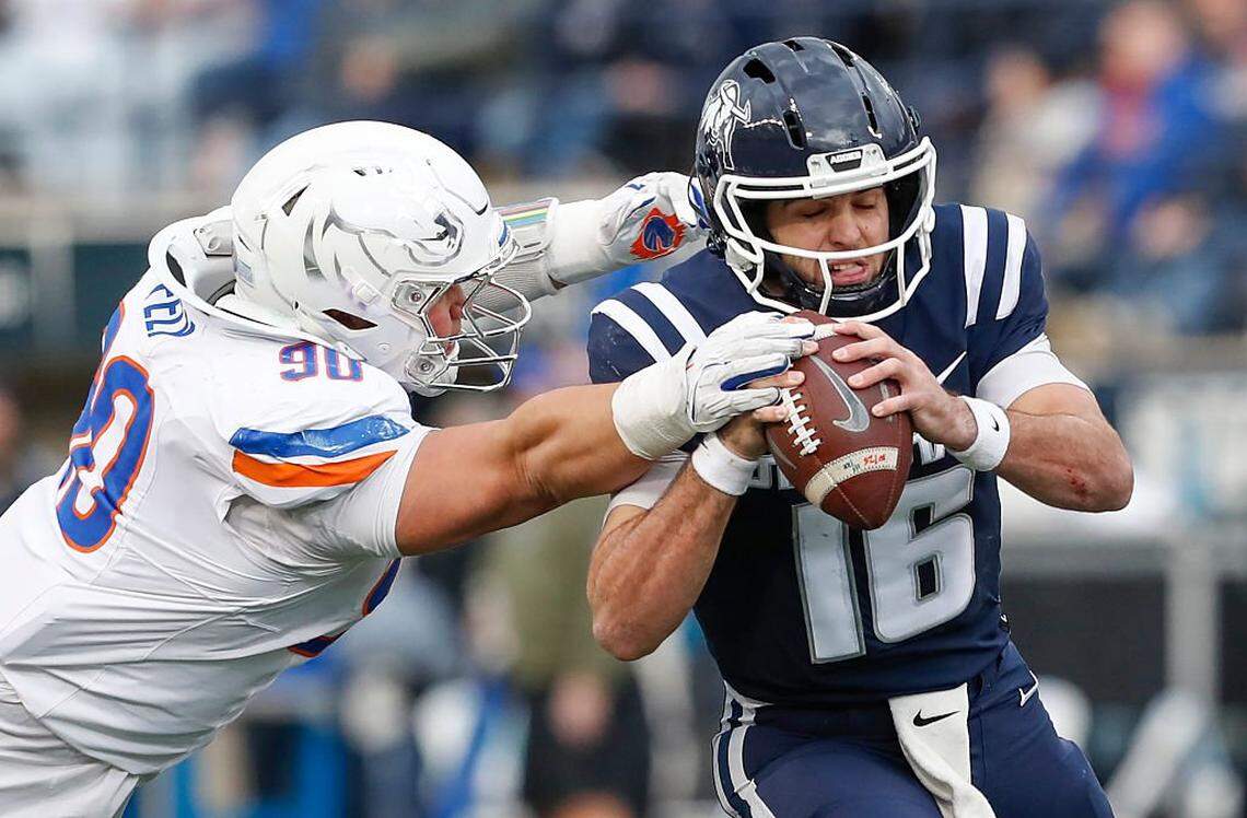 Boise State made life mostly miserable for Utah State quarterback Bryson Barnes on Friday, limiting him to 11-of-29 passing for 132 yards. Here he runs to avoid a sack by Braxton Fely. 