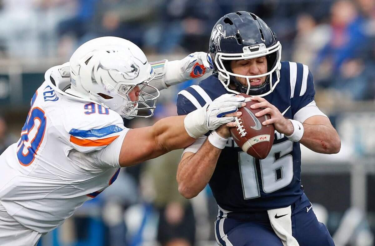 Boise State made life mostly miserable for Utah State quarterback Bryson Barnes on Friday, limiting him to 11-of-29 passing for 132 yards. Here he runs to avoid a sack by Braxton Fely.