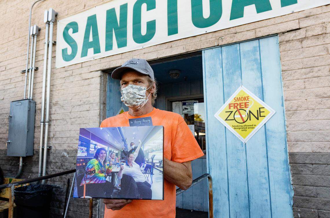 Interfaith Sanctuary resident Kevin Bullard holds a photograph of Debi Davis raising her hand in the air on a bowling outing with the homeless shelter staff in Boise. Bullard spoke about his favorite memories of Davis, who died of COVID-19 during her memorial at the shelter on Thursday, Sept. 16, 2021.