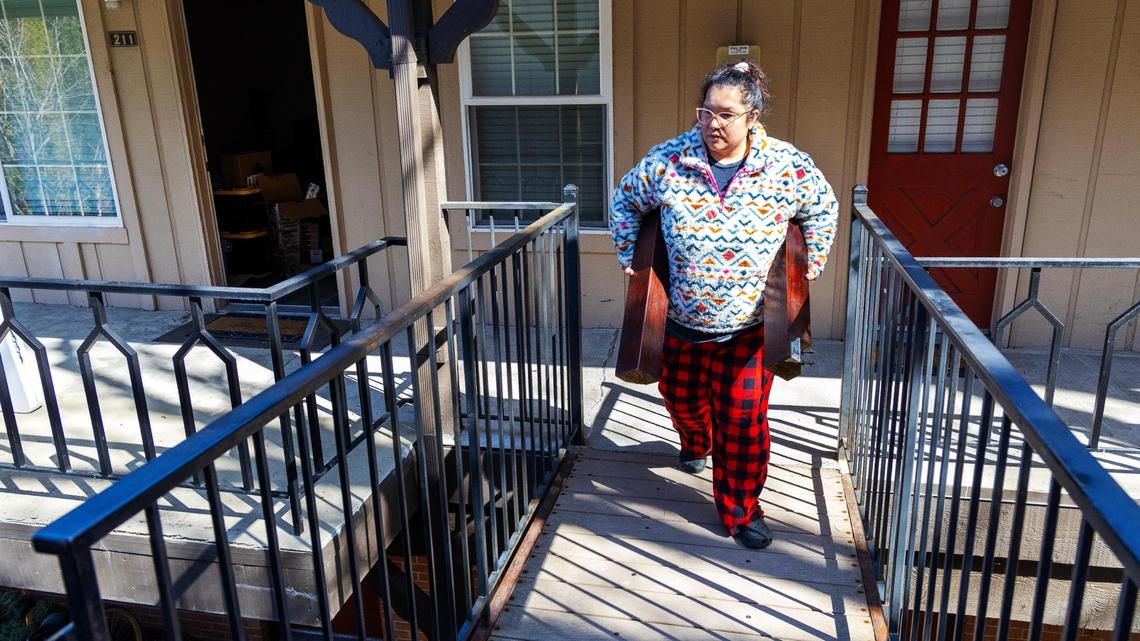Margarita Gomez moves furniture from her home at Cambridge Apartments. She works a full-time job and said Thursday that she had to miss three days of pay to move out.
