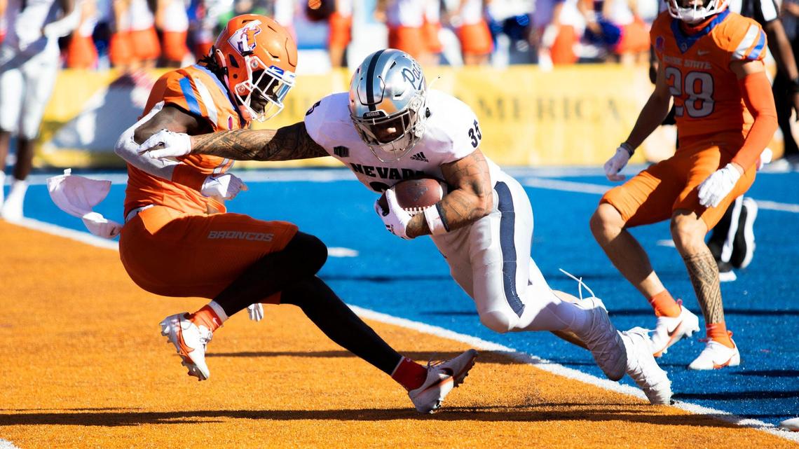 Nevada running back Toa Taua smashes into Boise State safety JL Skinner on a second-half touchdown run Saturday at Albertsons Stadium.