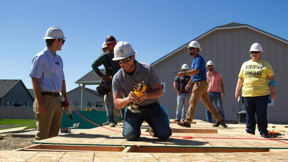 An employee of First Story prepares to cut the shape of a window out of plywood, before it becomes the start of a wall in a new Caldwell home, on June 14, 2023.