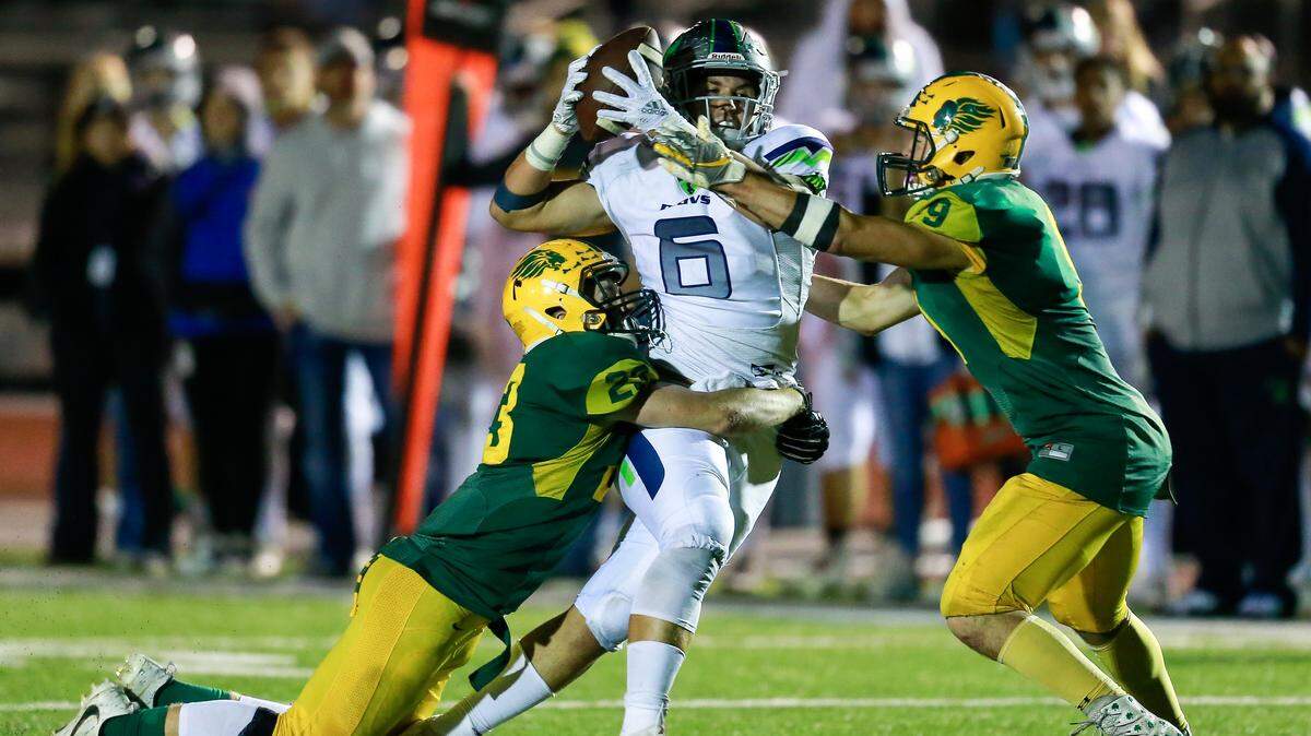Mountain View tight end Joey Elwell pulls down a reception between two Borah defenders on Thursday night at Dona Larsen Park in Boise. The Mavericks won 48-24.