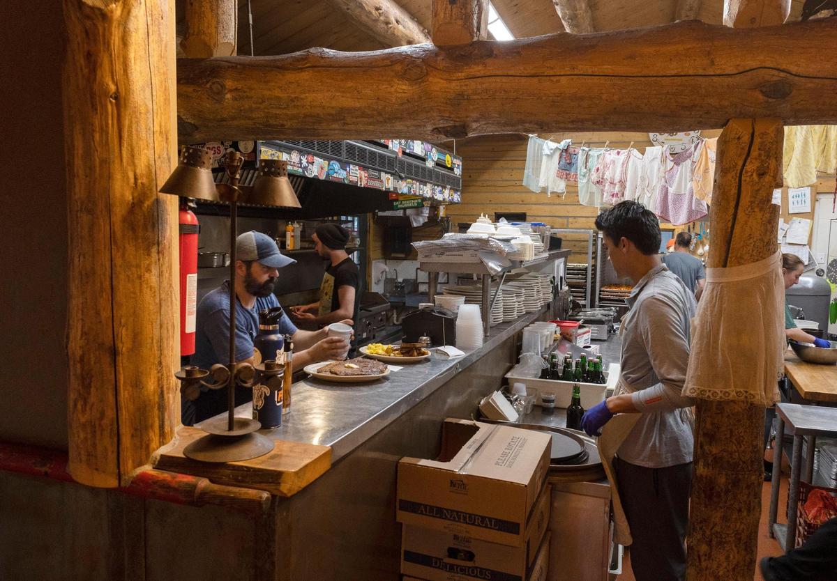 Cooks and servers work to breakfast orders out to customers at Stanley Baking Co. in June.
