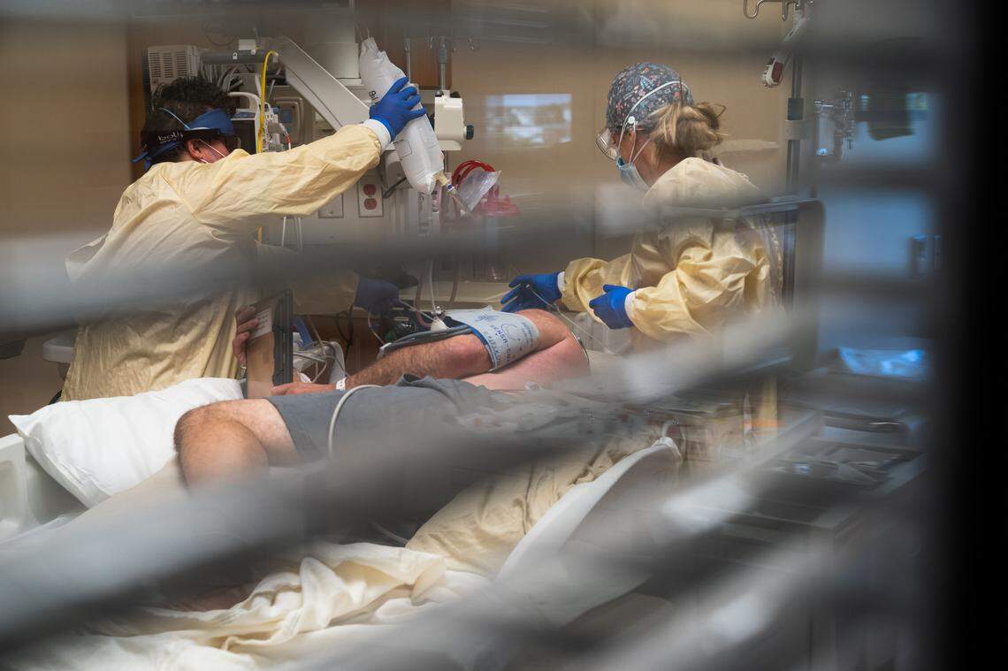 A patient in the ICU at St. Alphonsus Regional Medical Center in Boise talks via an iPad on Sept. 16, 2021, with his family as health care workers prepare to intubate him. The state declared crisis standards of care on Sept. 16.