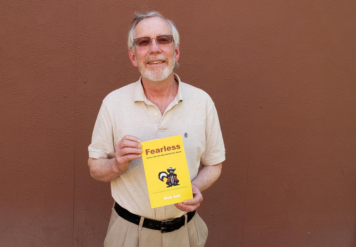 Author Rick Just holds a copy of his new book on the founder of Stinker gas stations, “Fearless: Farris Lind, the Man Behind the Skunk.”