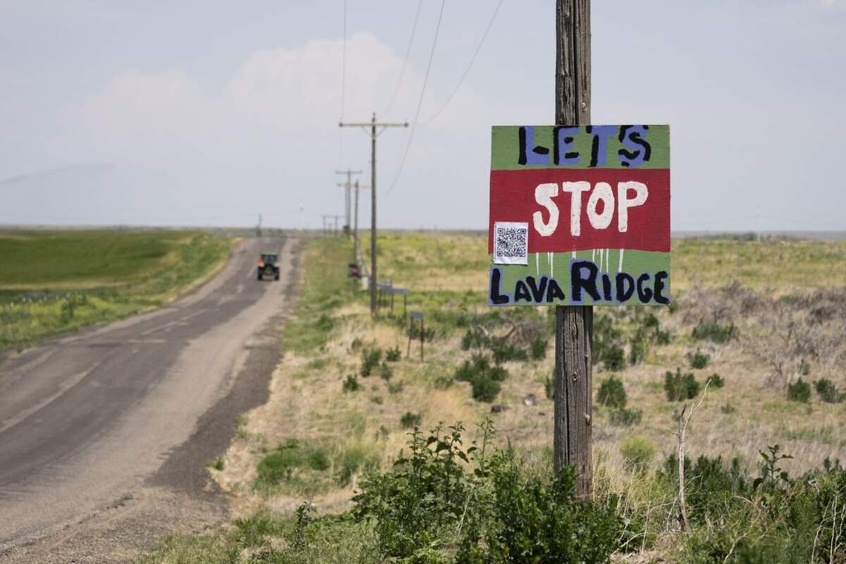 A tractor travels down Hunt Road in front of a “Let’s Stop Lava Ridge” sign near the historic site.