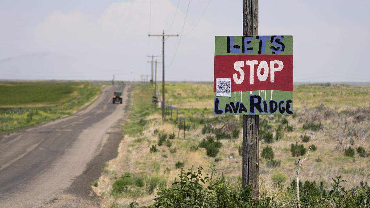 A tractor travels down Hunt Road in front of a “Let’s Stop Lava Ridge” sign near the Minidoka National Historic Site in 2023. President Donald Trump halted the project, which the Bureau of Land Management approved in December 2024, with an executive order.