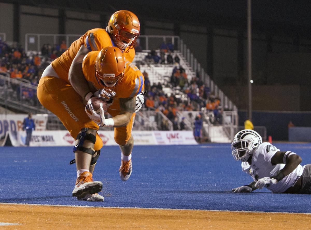 Boise State tight end Garrett Collingham dives into the end zone with some assistance from offensive lineman John Molchon during the Broncos’ 56-28 win over Colorado State last year at Albertsons Stadium.